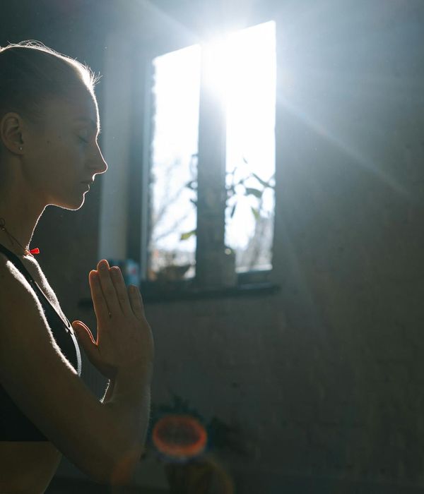 A serene woman with closed eyes, focusing on inner balance in a calm environment.